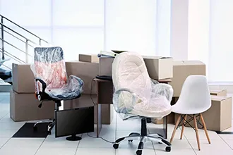 Office chairs and packed boxes arranged for a business relocation.