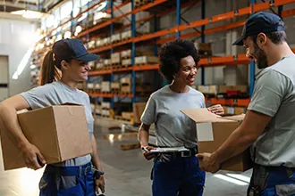 Warehouse workers handling packages, highlighting commercial moving services.