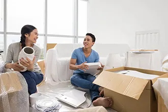 Couple unpacking boxes in a new home, demonstrating unpacking services.