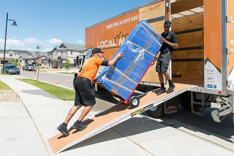 Experienced movers carefully load a wrapped item onto a truck, ensuring a smooth and efficient long-distance move in Norman, OK.